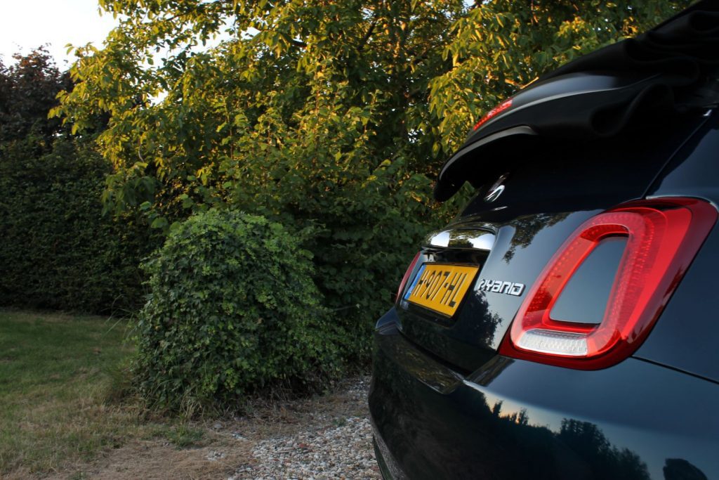 blauwe auto, kap omlaag, groen bosje