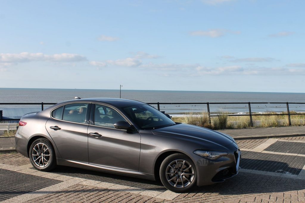 stenen weg, grijze auto voor zee, blauwe lucht, Alfa Romeo Giulia