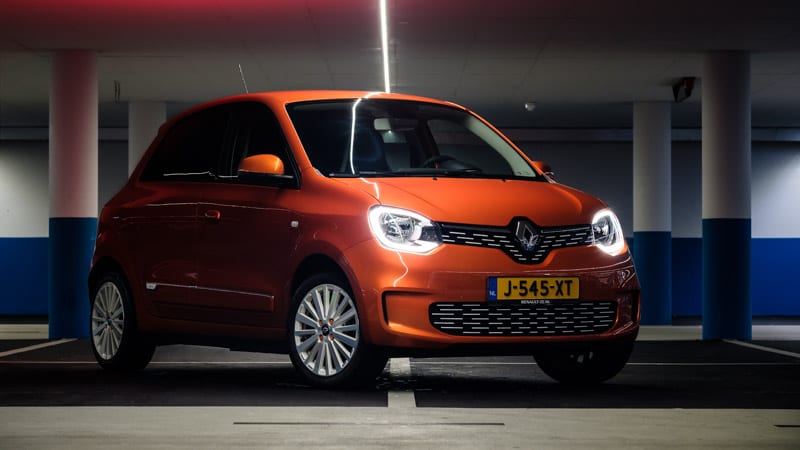 oranje Renault Twingo Electric voor rijtest schuin gefotografeerd