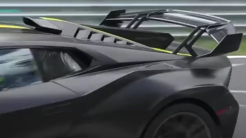 Spoiler en motordeksel Lamborghini Huracán STO, zwarte auto met gele streep, testauto op de Nürburgring