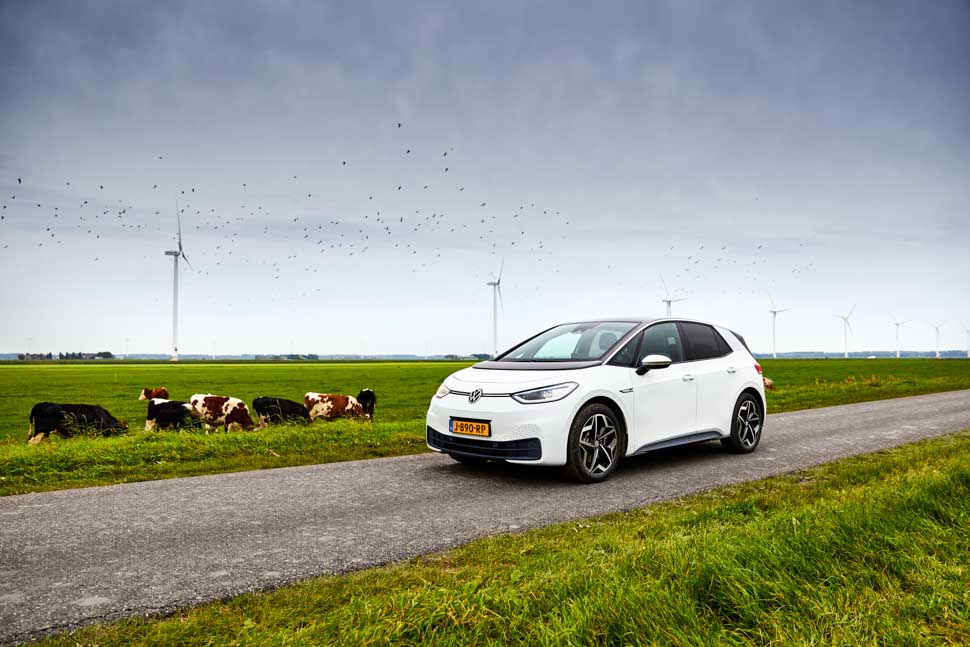 Volkswagen ID.3 in typisch Hollands landschap, weiland met koeien, windmolens en vogels in vlucht
