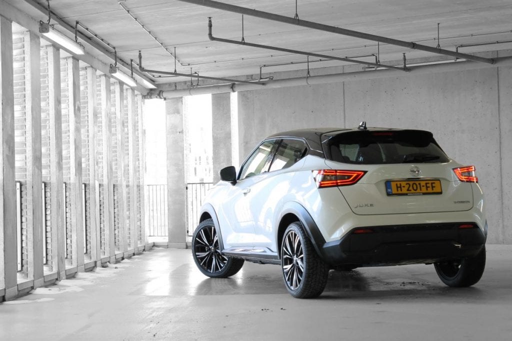 Achterzijde Nissan Juke, witte auto in parkeergarage, zwart wit foto