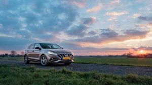 Hyundai i30 op dijkweg bij zonsondergang