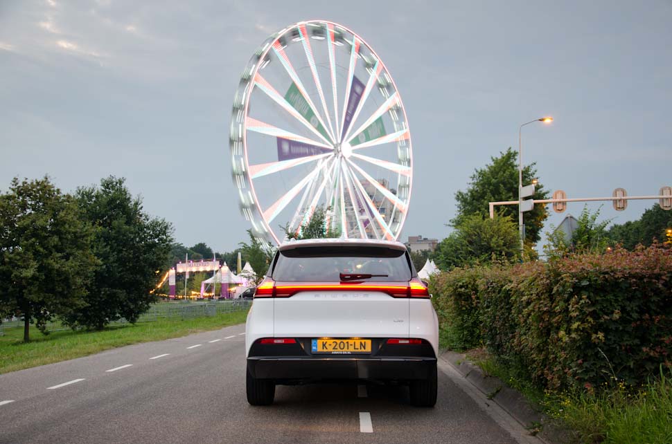 Achteraanzicht, achterzijde, achterkant Aiways U5, reuzenrad met verlichting, Ferris Wheel, fair, berm met heg, donkere lucht