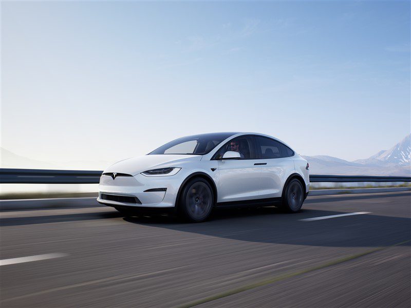 white Tesla Model X front driving